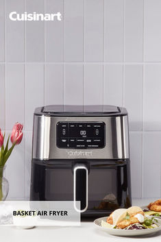 an air fryer sitting on top of a counter next to a plate of food