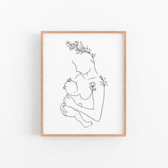 a black and white drawing of a woman holding a baby in her arms on a wall