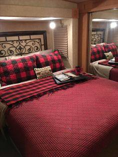 a red and black checkered bedspread in a bedroom with two mirrors on the wall