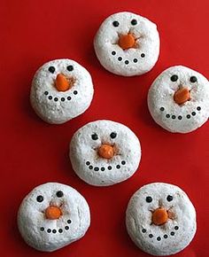 four snowman doughnuts are on a red surface with the words pin it