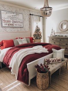 a bedroom decorated for christmas with red and white bedding, plaid comforter, wooden dressers, and holiday decorations