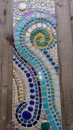 a close up of a wooden fence with a mosaic design on the top and bottom