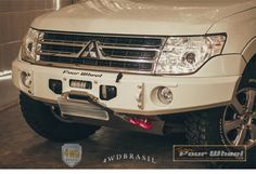 the front end of a white truck parked in a garage