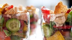 two glasses filled with different types of food and garnishes on top of each other