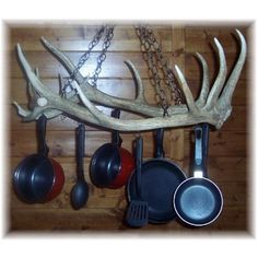 an antler's head is hanging on the wall with pots and pans