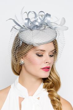 Be the envy of the party in this elegant felt fascinator. The round felt base is covered with satin ribbon loops, adorned with flighty feathers and topped off with a birdcage veil. This gorgeous piece is perfect for any special occasion. - Easy wear headband - Optional; tuck-a-way veil - Available in several other colors White Simple Gown, Felt Fascinator, Fascinator Hats Outfit, Grey Fascinator, Fascinator Hats Wedding, White Fascinator, Sinamay Hat, Kentucky Derby Fascinator, Sinamay Hats