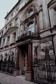 an old building with wrought iron fence around it