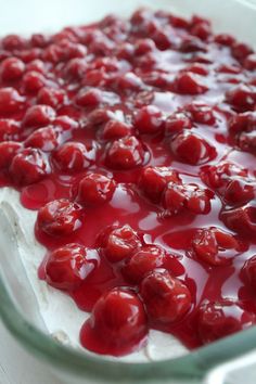 a dessert dish with cherries and cream in it