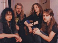 three men sitting next to each other with long hair