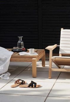 a pair of sandals sitting on top of a white tile floor next to a wooden table