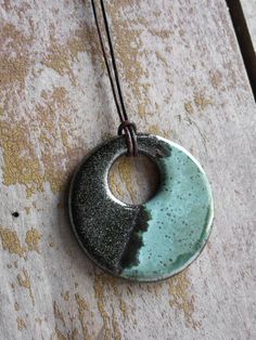 a necklace with a circular pendant hanging from it's side