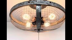 an old fashioned light fixture is hanging from the ceiling with wire and metal mesh around it