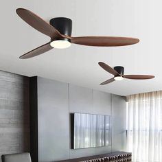 a living room with two ceiling fans in the middle and a couch on the other side