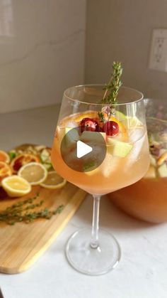 two glasses filled with drinks sitting next to each other on top of a wooden cutting board