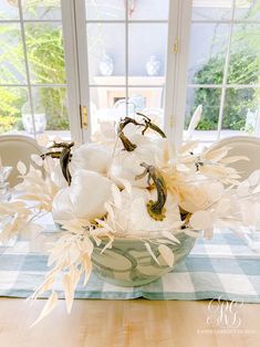 a bowl filled with white flowers on top of a table