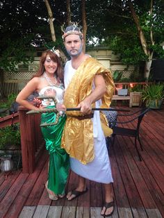 a man and woman dressed in costumes standing on a deck