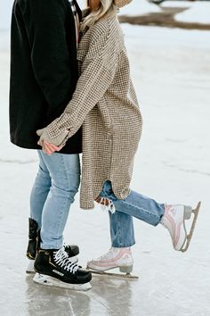 a man and woman are ice skating on an icy surface together, with one holding the other's hand