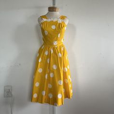 "Step into retro elegance with this vintage polka dot dress in vibrant yellow. Inspired by the iconic 1960s fashion, this handmade dress combines timeless charm with a modern twist. The yellow and white polka dot pattern adds a playful touch, perfect for sunny summer days. Crafted with attention to detail, this dress is available in size XS/S, ensuring a perfect fit. Embrace vintage vibes and make a stylish statement with this unique piece. era: 1960s label size: none marked [please check measur 1950s Style Polka Dot Dresses For Spring, Spring Polka Dot Vintage Dress, Yellow A-line Vintage Dress For Summer, Yellow Vintage A-line Dress For Spring, Yellow A-line Vintage Dress For Spring, Spring Yellow A-line Vintage Dress, Yellow Fitted Dress In 1950s Style, Yellow Cotton Retro Vintage Dress, Fitted Yellow Dress In 1950s Style