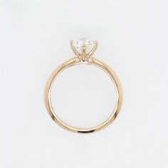 a yellow gold ring with a single diamond on the center and side stones at the top