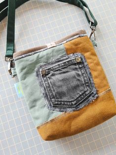 a handbag made out of old jeans on a piece of paper with a green strap