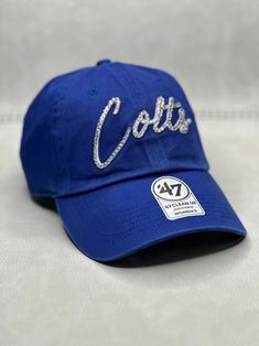 This is a royal blue IND Colts script 47 clean up adjustable hat that is hand embellished with varying sizes of genuine Swarovski silver crystals on the front logo.  This hat features over 150+ varying size Swarovski crystals.  - 100% Cotton - Matching fabric strap & buckle  - One Size Fits All - Raised Embroidered Logo - 150+ Swarovski translucent silver crystal individually placed by hand - Ready to ship in 1 week from San Diego, CA Bling Dodgers Hat, Rhinestone Football, Bling Hat, Sports Hat, Fabric Strap, Sport Hat, Womens Football, Silver Crystal, Adjustable Hat