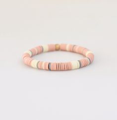 A lovely and lightweight bracelet to add to your arm stack. Details: 6mm soft vinyl heishi beads in an array of soft pink, cream + gray 6mm matte gold Hematite bead Strung on super strong stretch cord. Bracelet Size: There are 3 sizes available. The measurements represent the actual bracelet length. Each bracelet can b Pink Heishi Beads Stretch Bracelet, Pink Heishi Beads Bracelets, Everyday Pink Heishi Beads Stretch Bracelet, Heishi Jewelry, Arm Stack, Sweet Vibes, Heishi Bracelets, Clay Bracelets, Beaded Braclets