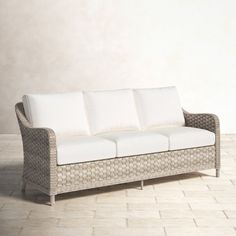 a white couch sitting on top of a tiled floor