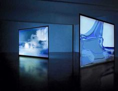 three framed images are shown in an empty room with blue light coming from the ceiling