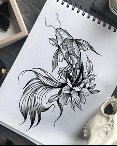 a drawing of a fish with flowers on it's back and an ink pen next to it