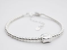 A dainty sterling silver bracelet made with 3mm silver beads and a solid silver Buddha charm. This bracelet looks lovely on it's own or stacked up with a few of them! The length of the bracelet is approximately 17cm with a 4cm extension chain.  There is also a 'Made with ♥' charm at the clasp. Beautifully presented in a tinysilver faux suede pouch. Sterling Silver Beaded Bracelets With Silver Clasp For Everyday, Minimalist Sterling Silver Bracelets With Silver Beads, Sterling Silver Beads Charm Bracelet, Sterling Silver Beaded Bracelets With Tiny Beads, Minimalist Sterling Silver Beaded Bracelet With Silver Beads, Everyday Silver Bracelets With Tiny Beads, Sterling Silver Bracelets With Tiny Beads For Everyday, Everyday Sterling Silver Bracelets With Tiny Beads, Lightning Bolt Necklace