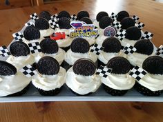 cupcakes decorated with oreo cookies and white frosting on a table top