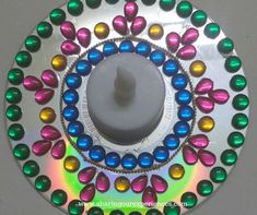 a circular metal object with multicolored beads on it