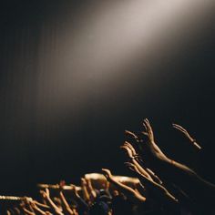 a crowd of people raising their hands up in the air at a music concert or show