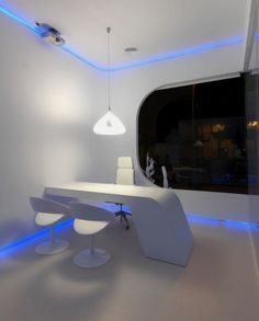 an office with white furniture and blue lighting