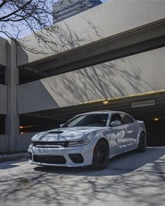 a white dodge charger parked in front of a building