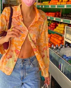 a woman standing in front of a fruit stand