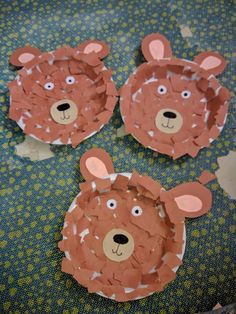 three paper plates shaped like bears sitting on top of a blue tablecloth covered floor