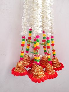 colorful decorations hanging from the ceiling with white and red pom - poms on them