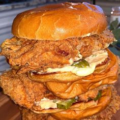 three fried chicken sandwiches stacked on top of each other