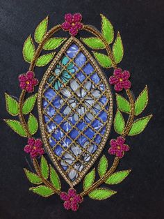 an embroidered brooch with flowers and leaves around it