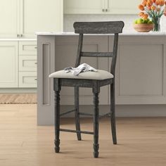 a wooden chair sitting in a kitchen next to an island with flowers on top of it