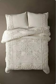 an image of a bed with white linens and pillows on it's side