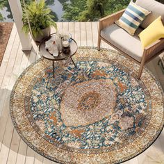 an outdoor area rug is shown with chairs and tables on the deck, along with potted plants