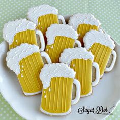 decorated cookies in the shape of beer mugs on a plate