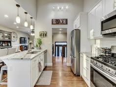 this kitchen has white cabinets and stainless steel appliances, along with an island in the center