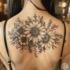 a woman's back with sunflowers and leaves tattoo on her upper back