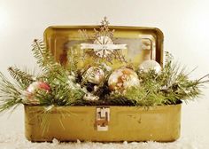 an old suitcase filled with ornaments and greenery