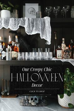 a halloween themed bar with liquor bottles and glasses on the counter, along with a sign that says our creepy chic halloween decor