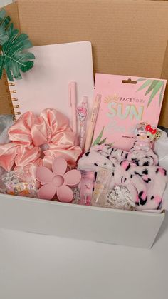 a box filled with lots of pink and white items next to a potted plant