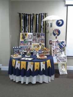 a table with pictures and other items on it in front of a window at an event